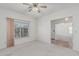 Cozy bedroom with a ceiling fan, carpeted floors, and natural lighting from the large window at 4207 W Soft Wind Dr, Glendale, AZ 85310