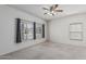 Comfortable bedroom featuring carpeted floors, a ceiling fan, and large windows for ample natural light at 4207 W Soft Wind Dr, Glendale, AZ 85310