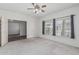 Bright bedroom featuring carpeted floors, a ceiling fan, a window and a doorway at 4207 W Soft Wind Dr, Glendale, AZ 85310