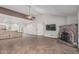 Open-concept living area featuring tile floors, brick fireplace, ceiling fan, and ample natural light at 4207 W Soft Wind Dr, Glendale, AZ 85310