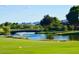 Scenic view of the golf course with a pond, fountain, bridge, and lush greenery at 4234 E Narrowleaf Dr, Gilbert, AZ 85298