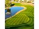 Aerial view of a lush green golf course featuring a pond and manicured fairways at 4234 E Narrowleaf Dr, Gilbert, AZ 85298