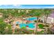Aerial view of the community pools with palm trees, lounge seating and beautiful landscaping in this active adult neighborhood at 4234 E Narrowleaf Dr, Gilbert, AZ 85298