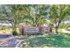 Entrance to Trilogy Clubhouse, Golf Club, and Grill framed by lush green trees, lawn and flowering landscape at 4234 E Narrowleaf Dr, Gilbert, AZ 85298