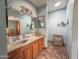 Well lit bathroom with dual sinks, wood cabinets and decorative mirrors in a home for sale at 4621 E Desert Forest Trl, Cave Creek, AZ 85331