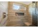 Modern shower with wood-look tile, built-in niche, and a window, providing a spa-like experience at 4762 E White Aster St, Phoenix, AZ 85044