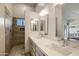 Bright bathroom features a dual vanity, modern lights, and a tiled walk-in shower at 4762 E White Aster St, Phoenix, AZ 85044