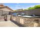 Outdoor kitchen features a stainless steel grill, built-in storage, and a stone countertop for cooking and entertaining at 4762 E White Aster St, Phoenix, AZ 85044