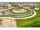 Aerial view of a landscaped roundabout surrounded by lush greenery and palm trees within a residential area at 5518 S Dillon Cir, Mesa, AZ 85212