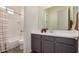 Bathroom with a gray vanity, modern fixtures, and a shower-tub combination with white tile and a stylish shower curtain at 5518 S Dillon Cir, Mesa, AZ 85212