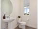 Well-lit powder room features a pedestal sink, round mirror, and wood-look tile floor at 5518 S Dillon Cir, Mesa, AZ 85212