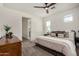 Bedroom features a ceiling fan, plush bedding, decor, and an en-suite bath at 5518 S Dillon Cir, Mesa, AZ 85212