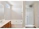 Bright bathroom showcasing a vanity with cabinets, a tub, and a glass-enclosed shower at 5553 W Minton Ave, Laveen, AZ 85339