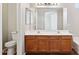 Bathroom featuring double sinks, a vanity with cabinets, a mirror, and a toilet at 5553 W Minton Ave, Laveen, AZ 85339