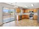 Bright kitchen featuring stainless steel appliances, wood cabinets, tile floors, and sliding glass door to the backyard at 5553 W Minton Ave, Laveen, AZ 85339