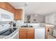 Functional kitchen with stainless steel sink, white appliances, and access to the living room at 5735 E Mcdowell Rd # 464, Mesa, AZ 85215