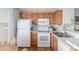 Bright kitchen with wooden cabinets, white appliances, and marble countertops at 5735 E Mcdowell Rd # 464, Mesa, AZ 85215