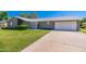 A single story home with a two car garage, privacy screen, and a large green front yard at 6127 N 16Th Pl, Phoenix, AZ 85016