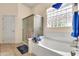 Bright bathroom featuring a soaking tub, glass block window, and separate shower at 6141 S Bradshaw Way, Chandler, AZ 85249