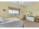 Bedroom with a large window, ceiling fan, and queen bed has neutral colored walls and carpet at 6141 S Bradshaw Way, Chandler, AZ 85249