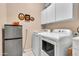 Laundry room with washer, dryer, storage and mini refrigerator; features a neutral color scheme at 6141 S Bradshaw Way, Chandler, AZ 85249