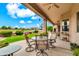 Covered patio featuring outdoor seating, vibrant green grass, and golf course views at 6141 S Bradshaw Way, Chandler, AZ 85249