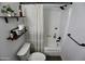 Well-lit bathroom featuring a shower with sleek black fixtures and floating shelving at 711 W El Alba Way, Chandler, AZ 85225
