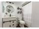 Bright bathroom with contemporary vanity, sleek mirror, and a shower with an elegant striped curtain at 711 W El Alba Way, Chandler, AZ 85225