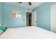 The bedroom is painted a cool blue with a ceiling fan and a bright window, allowing ample natural light at 711 W El Alba Way, Chandler, AZ 85225