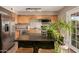 Well-lit kitchen featuring stainless steel appliances, wooden cabinets and island with a granite countertop at 711 W El Alba Way, Chandler, AZ 85225