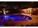 Backyard pool is lit with blue underwater lighting with a covered patio space for relaxing near the water at 711 W El Alba Way, Chandler, AZ 85225