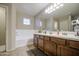 Bright bathroom featuring dual sinks, a soaking tub, and updated fixtures at 7242 S 48Th Gln, Laveen, AZ 85339