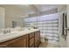 Bright bathroom featuring a double sink vanity and a stylish striped shower curtain at 7242 S 48Th Gln, Laveen, AZ 85339
