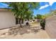 Backyard featuring gravel ground cover, lush trees and desert flora, and a charming pizza oven at 7492 E Buteo Dr, Scottsdale, AZ 85255