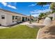 Expansive backyard with artificial turf, a covered patio, a pool and meticulous desert landscaping for year-round enjoyment at 7492 E Buteo Dr, Scottsdale, AZ 85255