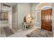 Entryway with a wooden front door, decorative table, mirror, rug and light tiled floor at 7492 E Buteo Dr, Scottsdale, AZ 85255