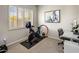 Bright home gym with exercise bike, desk, and modern decor, offering a private fitness space at 7492 E Buteo Dr, Scottsdale, AZ 85255