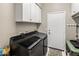 Functional laundry room with modern appliances and ample storage space, including overhead cabinets at 7492 E Buteo Dr, Scottsdale, AZ 85255
