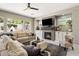 Inviting living room featuring a brick fireplace, large windows, and comfortable, neutral-toned furniture at 7492 E Buteo Dr, Scottsdale, AZ 85255