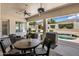 Covered patio featuring a beautiful pool view, a dining table, and comfortable seating at 7492 E Buteo Dr, Scottsdale, AZ 85255