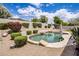Inviting pool with lush landscaping, built-in seating, and a charming pizza oven, perfect for outdoor entertaining at 7492 E Buteo Dr, Scottsdale, AZ 85255