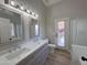Bright bathroom showcasing dual sinks, stylish vanity, modern mirrors, and outdoor access at 8319 E Plata Ave, Mesa, AZ 85212