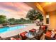 Relaxing outdoor pool area with seating, a fire pit, and views of a serene waterfront at 921 E Canyon Way, Chandler, AZ 85249