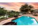 Inviting backyard with a pool, waterfront view, outdoor fireplace, and charming string lights at 921 E Canyon Way, Chandler, AZ 85249