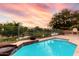 Stunning pool with stone patio and fire pit overlooking picturesque views and the calm lake behind the property at 921 E Canyon Way, Chandler, AZ 85249
