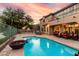 Gorgeous backyard with a sparkling pool, stone patio, outdoor fireplace, and covered seating area at 921 E Canyon Way, Chandler, AZ 85249