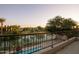 Balcony with a view of a serene pond and lush greenery at sunset, enhanced by string lights at 921 E Canyon Way, Chandler, AZ 85249