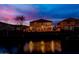 Exterior view of a beautiful two story home with string lights reflecting on the nearby pond at dusk at 921 E Canyon Way, Chandler, AZ 85249