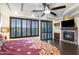 Bright primary bedroom with wood floors, stone fireplace, plantation shutters, and a ceiling fan at 921 E Canyon Way, Chandler, AZ 85249