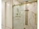 Modern shower with gold hardware, marble tiles, and dual showerheads, creating a spa-like experience at 921 E Canyon Way, Chandler, AZ 85249